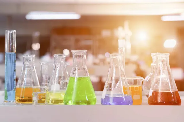 Labu dan gelas kimia laboratorium berisi larutan berwarna